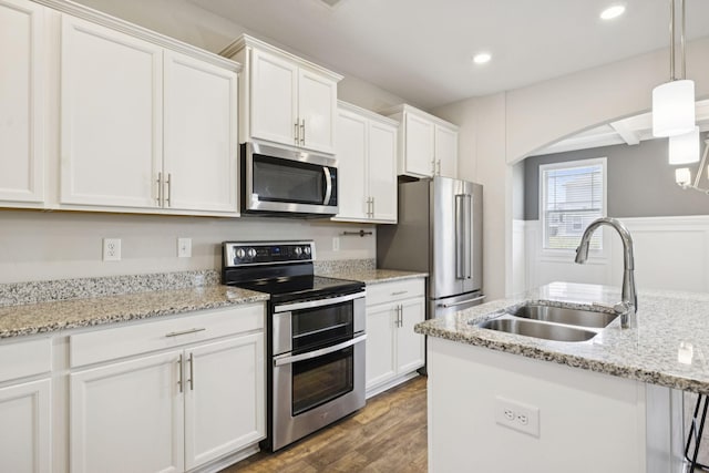 2237 Pathfinder Dr, Murfreesboro, TN 37127 - kitchen with appliances with stainless steel finishes, dark wood finished floors, white cabinetry, arched walkways, and pendant lighting