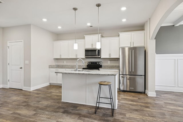 2237 Pathfinder Dr, Murfreesboro, TN 37127 - kitchen with stainless steel appliances, arched walkways, a center island with sink, recessed lighting, and white cabinets