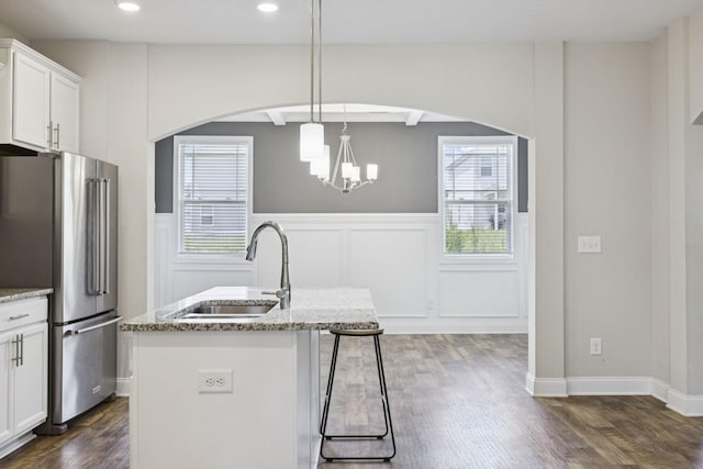 2237 Pathfinder Dr, Murfreesboro, TN 37127 - kitchen featuring arched walkways, dark wood finished floors, freestanding refrigerator, light stone countertops, and wainscoting
