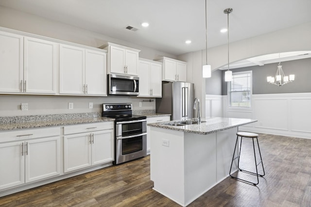 2237 Pathfinder Dr, Murfreesboro, TN 37127 - kitchen featuring appliances with stainless steel finishes, wainscoting, white cabinetry, a chandelier, and dark wood-type flooring