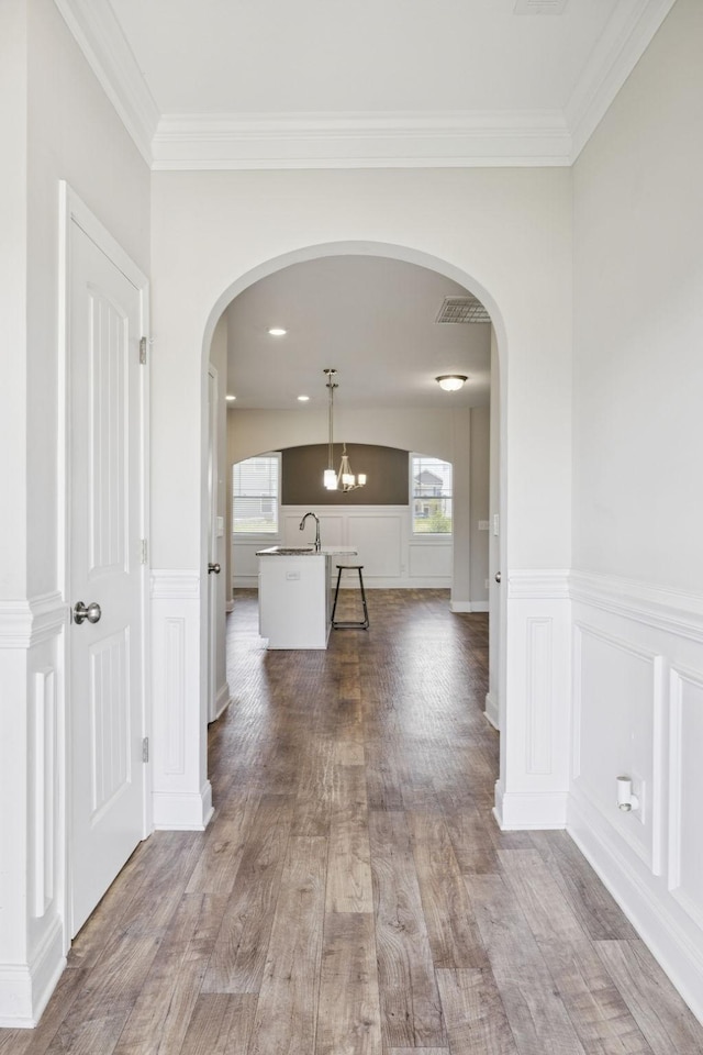 2237 Pathfinder Dr, Murfreesboro, TN 37127 - hall featuring healthy amount of natural light, arched walkways, wood finished floors, a decorative wall, and a wainscoted wall