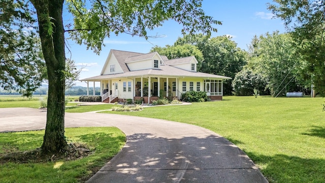 702 John Windrow Rd, Eagleville, TN 37060 - farmhouse featuring a front lawn, a sunroom, a porch, driveway, and roof with shingles