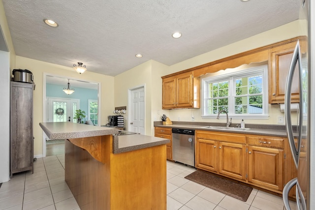 702 John Windrow Rd, Eagleville, TN 37060 - kitchen featuring appliances with stainless steel finishes, a kitchen island, light tile patterned floors, brown cabinetry, and a textured ceiling