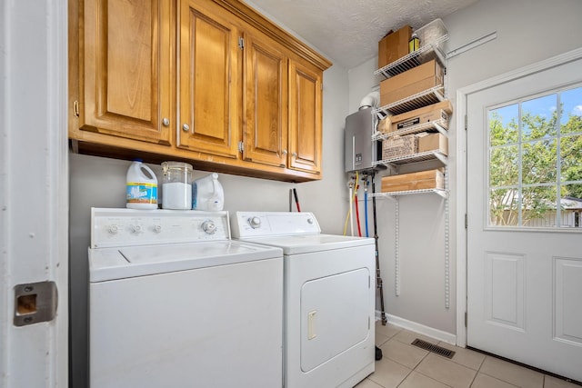 702 John Windrow Rd, Eagleville, TN 37060 - laundry room featuring cabinet space, separate washer and dryer, light tile patterned floors, and water heater