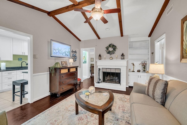 914 E Northfield Blvd, Murfreesboro, TN 37130 - living room featuring a ceiling fan, a brick fireplace, dark wood finished floors, and wainscoting