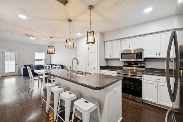 4826 Chelanie Cir, Murfreesboro, TN 37129 - kitchen with stainless steel appliances, white cabinets, recessed lighting, a breakfast bar, and hanging light fixtures