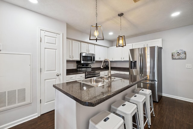 4826 Chelanie Cir, Murfreesboro, TN 37129 - kitchen with appliances with stainless steel finishes, dark wood finished floors, white cabinets, a breakfast bar, and recessed lighting