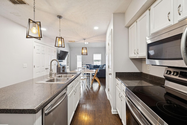 4826 Chelanie Cir, Murfreesboro, TN 37129 - kitchen with appliances with stainless steel finishes, dark countertops, dark wood finished floors, a textured ceiling, and white cabinets