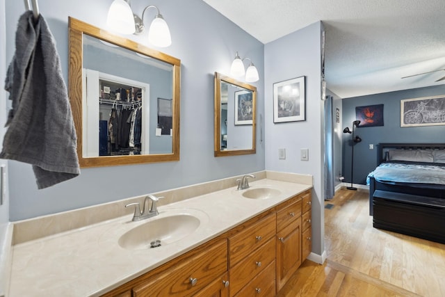 2261 High Meadow Dr, Murfreesboro, TN 37129 - ensuite bathroom featuring wood finished floors, double vanity, and a textured ceiling