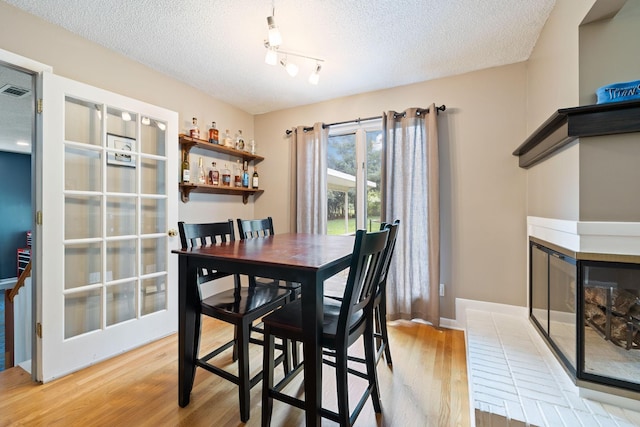 2261 High Meadow Dr, Murfreesboro, TN 37129 - dining area with a textured ceiling, wood finished floors, and a multi sided fireplace