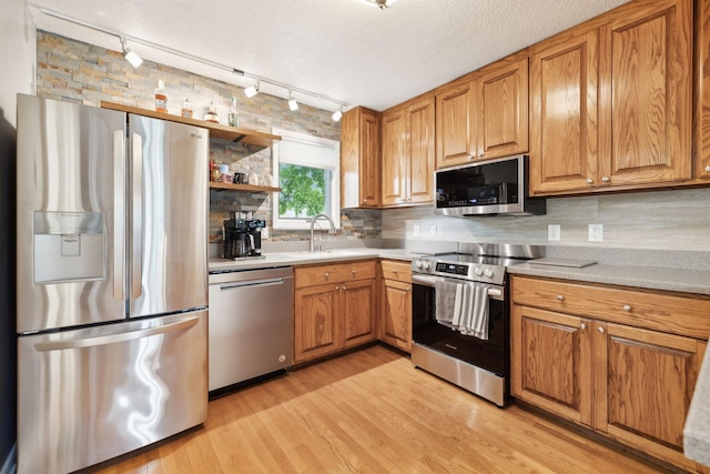 2261 High Meadow Dr, Murfreesboro, TN 37129 - kitchen with track lighting, appliances with stainless steel finishes, tasteful backsplash, light wood finished floors, and light countertops
