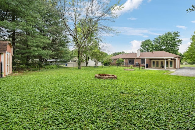 2261 High Meadow Dr, Murfreesboro, TN 37129 - fenced backyard with an outdoor fire pit, a patio, a storage unit, and french doors