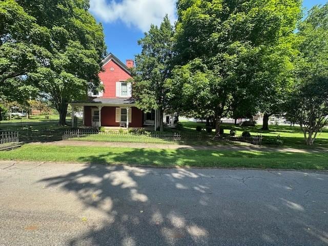 103 Cowan St W, Cowan, TN 37318 - view of front facade featuring covered porch, a front lawn, and a chimney