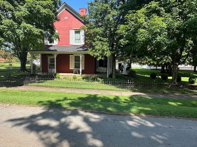 103 Cowan St W, Cowan, TN 37318 - view of front of property featuring covered porch, a chimney, and a fenced front yard