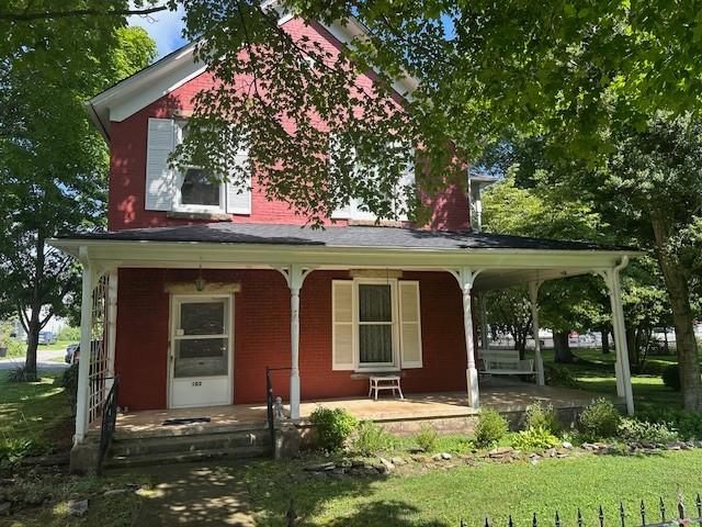 103 Cowan St W, Cowan, TN 37318 - view of front of property with covered porch, a front yard, and brick siding