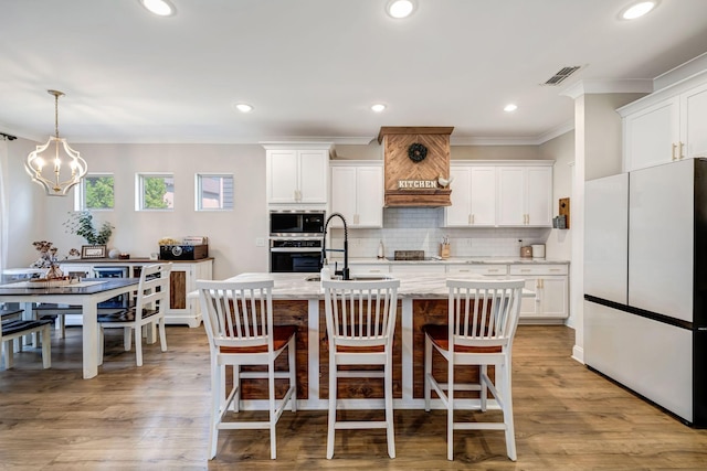 3612 Shady Forest Dr, Murfreesboro, TN 37128 - kitchen with stainless steel appliances, crown molding, white cabinetry, a center island with sink, and backsplash