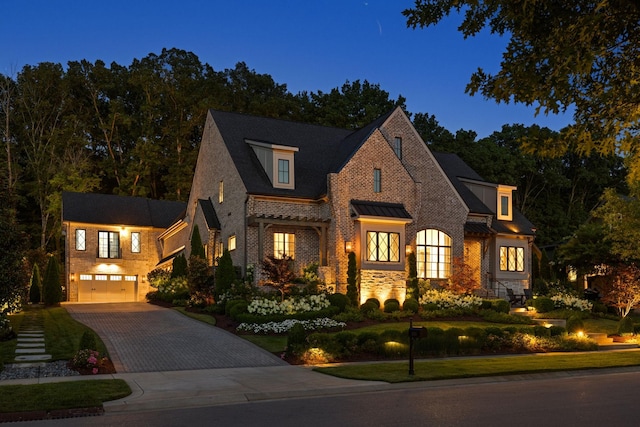 8524 Heirloom Blvd, College Grove, TN 37046 - view of front facade featuring decorative driveway, an attached garage, brick siding, a standing seam roof, and a metal roof
