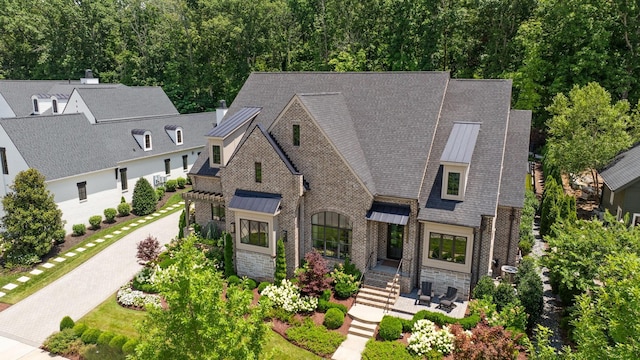 8524 Heirloom Blvd, College Grove, TN 37046 - view of front of home with a standing seam roof, brick siding, stone siding, and a shingled roof