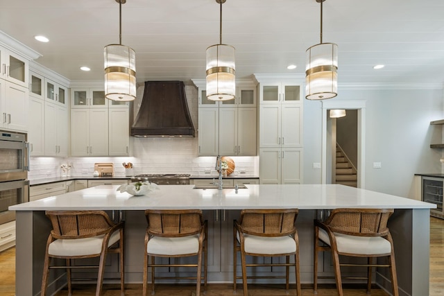 8524 Heirloom Blvd, College Grove, TN 37046 - kitchen featuring stainless steel double oven, custom exhaust hood, backsplash, a center island with sink, and beverage cooler