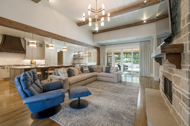 8524 Heirloom Blvd, College Grove, TN 37046 - living area featuring a chandelier, beam ceiling, light wood-style flooring, and a fireplace