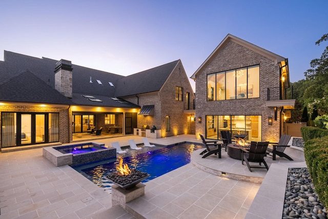 8524 Heirloom Blvd, College Grove, TN 37046 - pool at dusk featuring a fire pit, a patio area, and a pool with connected hot tub