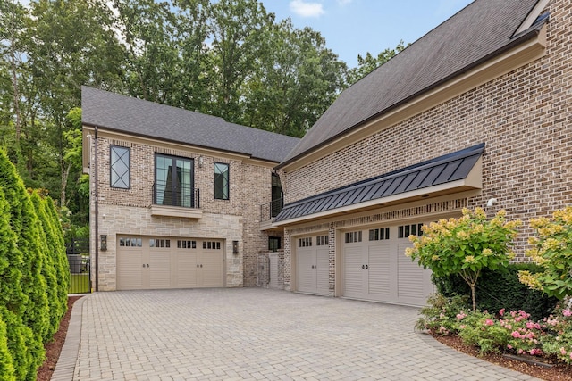 8524 Heirloom Blvd, College Grove, TN 37046 - view of side of property with decorative driveway, an attached garage, stone siding, and brick siding