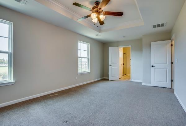 107 Clavie Crew Ln, Spring Hill, TN 37174 - unfurnished bedroom with a tray ceiling, carpet, crown molding, and ceiling fan