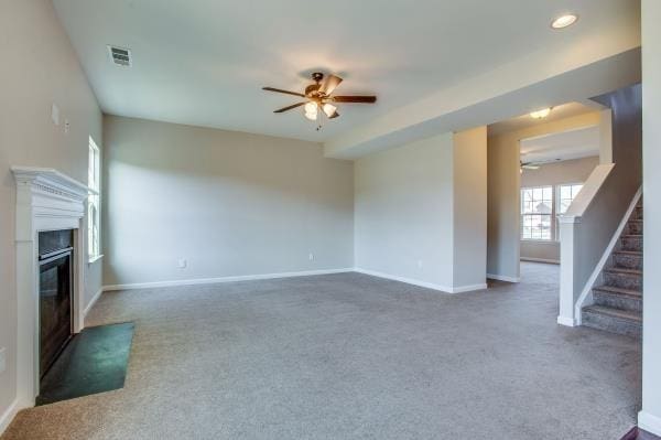 107 Clavie Crew Ln, Spring Hill, TN 37174 - unfurnished living room with a ceiling fan, carpet flooring, stairs, and a fireplace with flush hearth