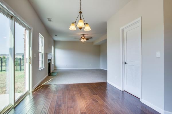 107 Clavie Crew Ln, Spring Hill, TN 37174 - spare room with healthy amount of natural light, a fireplace, dark wood-style floors, and a ceiling fan