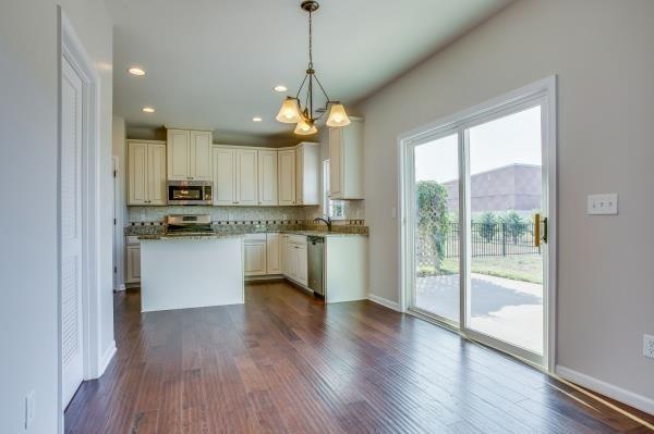 107 Clavie Crew Ln, Spring Hill, TN 37174 - kitchen featuring a chandelier, decorative backsplash, dark wood-type flooring, appliances with stainless steel finishes, and a kitchen island