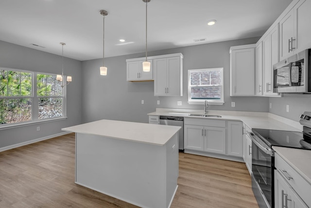 209 E Quail Hollow Way, Dickson, TN 37055 - kitchen with appliances with stainless steel finishes, a kitchen island, light wood finished floors, white cabinetry, and recessed lighting