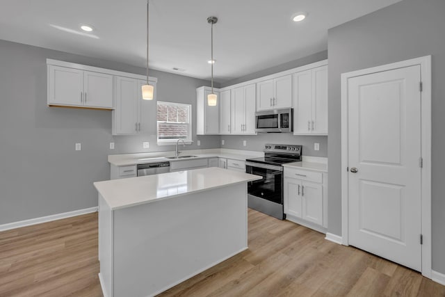 209 E Quail Hollow Way, Dickson, TN 37055 - kitchen with appliances with stainless steel finishes, white cabinetry, light wood-style floors, a center island, and light countertops