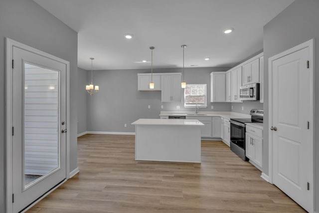 209 E Quail Hollow Way, Dickson, TN 37055 - kitchen with appliances with stainless steel finishes, white cabinets, a kitchen island, light countertops, and recessed lighting