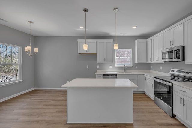 209 E Quail Hollow Way, Dickson, TN 37055 - kitchen with appliances with stainless steel finishes, a center island, white cabinets, light wood-style flooring, and recessed lighting