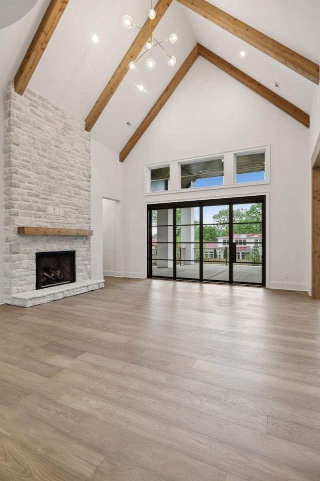 512 Wilson Pike, Brentwood, TN 37027 - unfurnished living room featuring high vaulted ceiling, a stone fireplace, beam ceiling, and wood finished floors