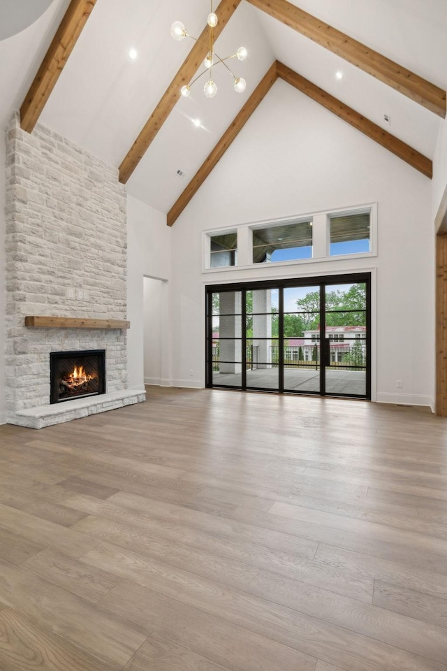 512 Wilson Pike, Brentwood, TN 37027 - unfurnished living room with high vaulted ceiling, a stone fireplace, beamed ceiling, and wood finished floors