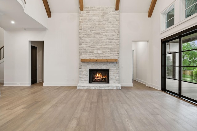 512 Wilson Pike, Brentwood, TN 37027 - unfurnished living room featuring a high ceiling, beamed ceiling, a fireplace, wood finished floors, and stairway