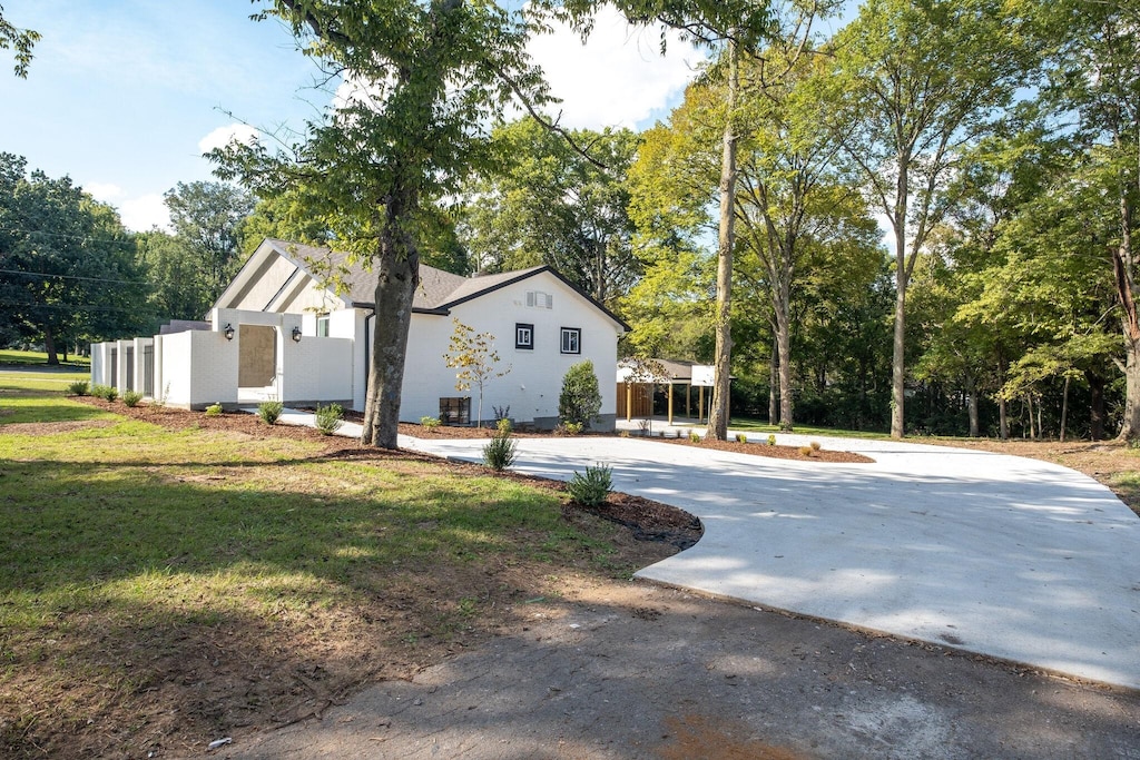 716 Elysian Fields Rd, Nashville, TN 37204 - view of side of property with a lawn and view of wooded area