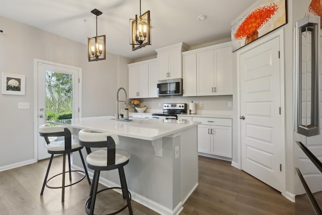 3225 Brookberry Ln, Murfreesboro, TN 37129 - kitchen featuring a kitchen island with sink, dark wood-style flooring, a chandelier, appliances with stainless steel finishes, and white cabinetry