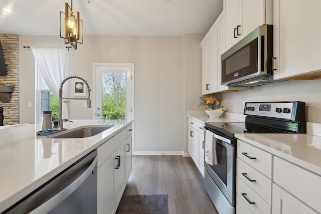 3225 Brookberry Ln, Murfreesboro, TN 37129 - kitchen with appliances with stainless steel finishes, light countertops, dark wood-style flooring, pendant lighting, and white cabinetry