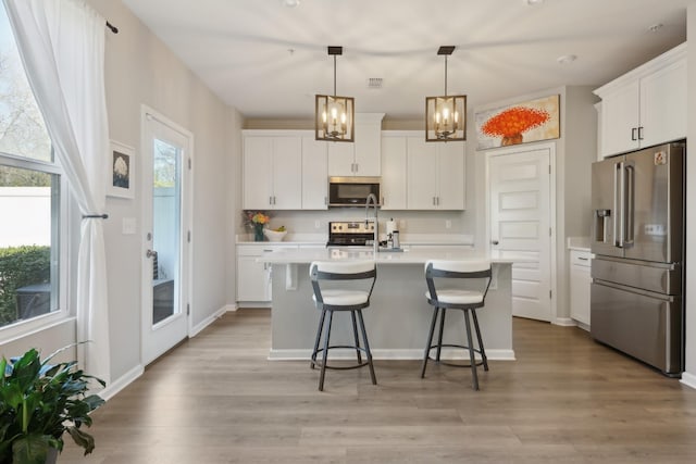 3225 Brookberry Ln, Murfreesboro, TN 37129 - kitchen with stainless steel appliances, light countertops, a kitchen breakfast bar, and light wood-type flooring