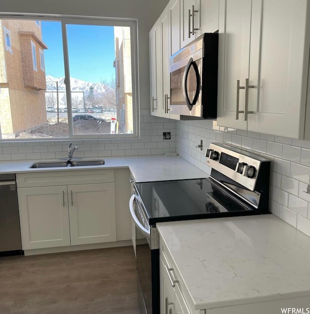 5491 W Fade Ct S Unit 191, West Valley City, UT 84120 - kitchen with hardwood / wood-style floors, white cabinetry, backsplash, appliances with stainless steel finishes, and sink