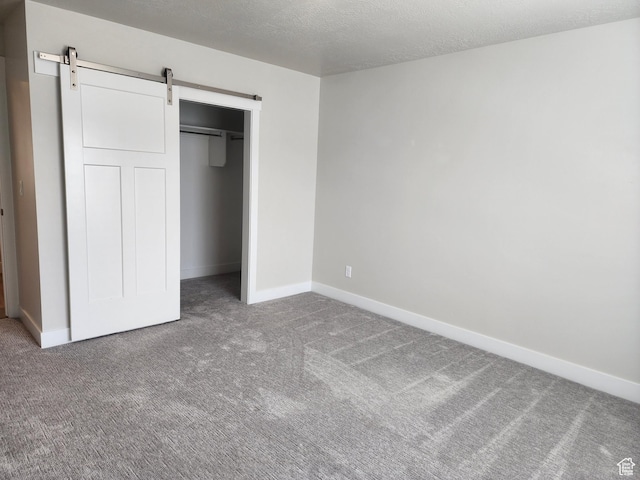 9786 N Aaron Ave E Unit 221, Eagle Mountain, UT 84005 - unfurnished bedroom with a barn door, baseboards, and carpet floors