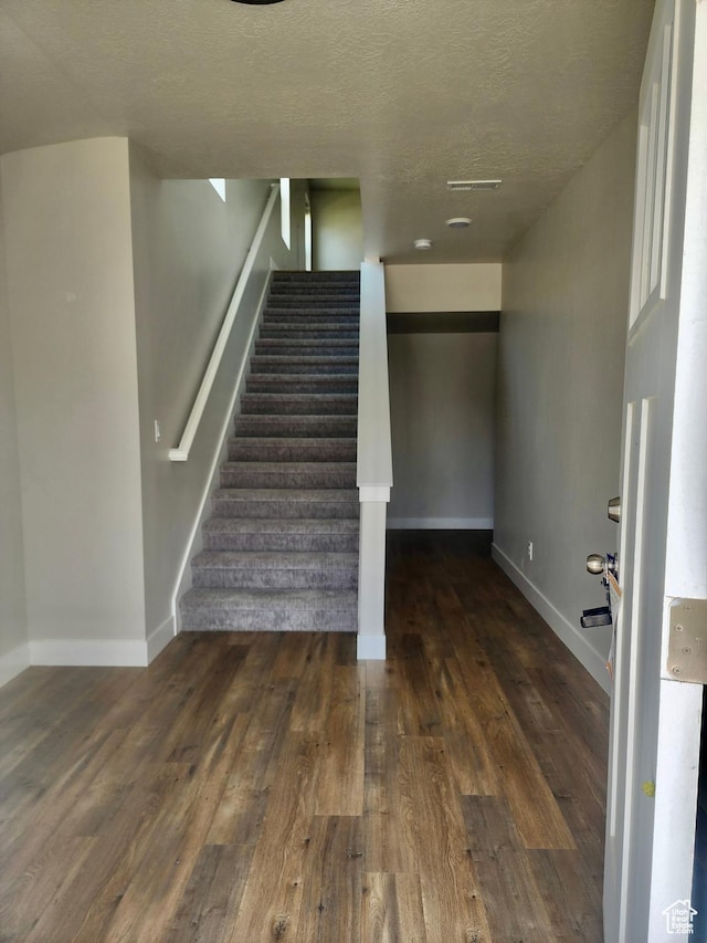 9786 N Aaron Ave E Unit 221, Eagle Mountain, UT 84005 - staircase featuring a textured ceiling, wood finished floors, baseboards, and visible vents