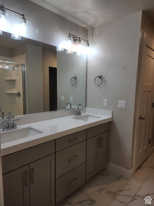 9786 N Aaron Ave E Unit 221, Eagle Mountain, UT 84005 - bathroom featuring double vanity, marble finish floor, a sink, and a stall shower