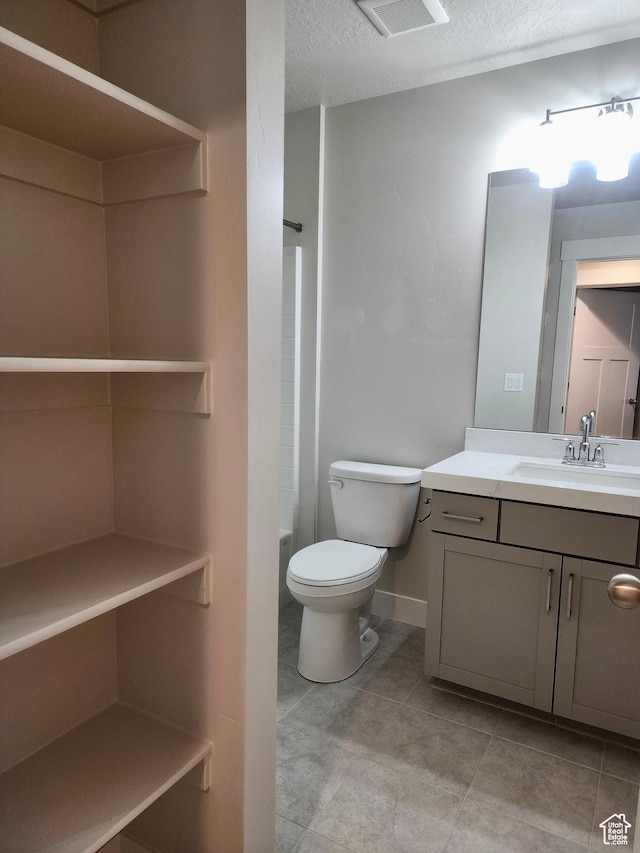 9786 N Aaron Ave E Unit 221, Eagle Mountain, UT 84005 - full bath with a textured ceiling, vanity, visible vents, toilet, and tile patterned floors