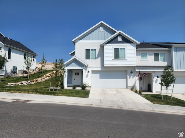 9786 N Aaron Ave E Unit 221, Eagle Mountain, UT 84005 - view of front of property with a front yard, an attached garage, board and batten siding, concrete driveway, and stucco siding