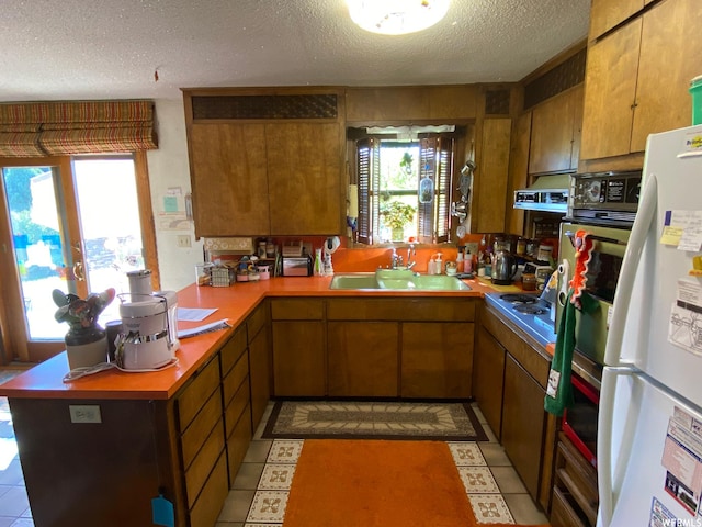 2406 Smokey Canyon Rd, Auburn, WY 83111 - kitchen featuring kitchen peninsula, a textured ceiling, sink, and white refrigerator
