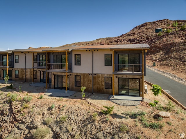 1185 S Murphy Ln Unit 105D, Moab, UT 84532 - back of property with a balcony, a patio, a mountain view, and stucco siding