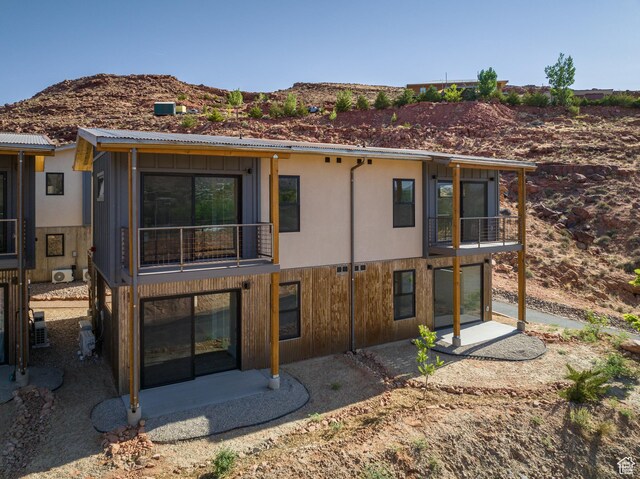 1185 S Murphy Ln Unit 105D, Moab, UT 84532 - back of house featuring a balcony, a mountain view, a patio area, and central AC